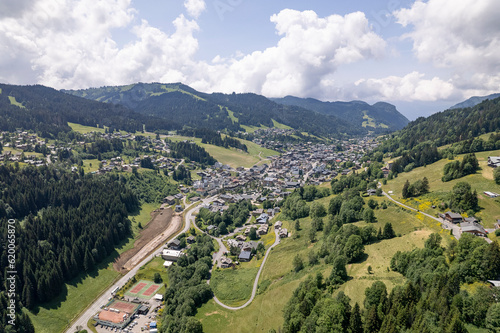 French Alps valley with village Les Gets seen from a mountain slope during summer. Ski area mountainous winter sports region.