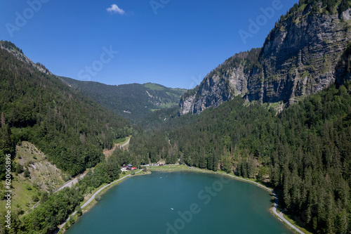 Montriond lake seen from above. Aerial of French Alps mountain range and leisure melt water pond during summer. photo