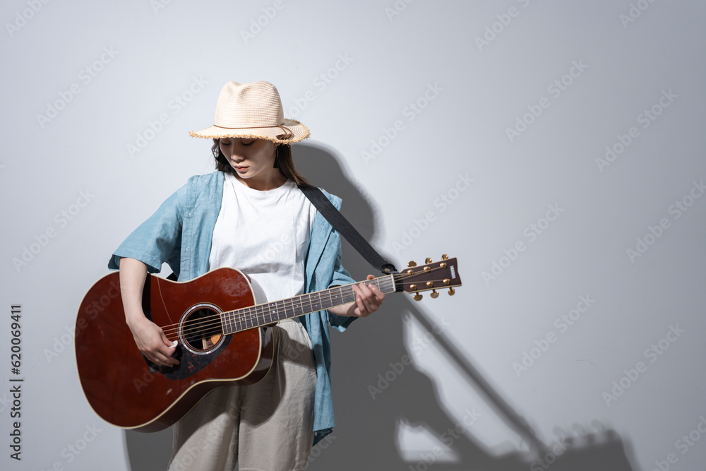 Fototapeta premium ギターを弾く若い女性