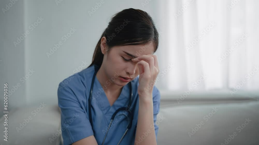 Tired depressed young asian woman nurse in uniform suffer from headache after hard working. Woman doctor feels burnout and shoulder neck pain . Physician burnout Tired depressed young asian woman nurse in uniform suffer from headache after hard working. Woman doctor feels burnout and shoulder neck pain . Physician burnout