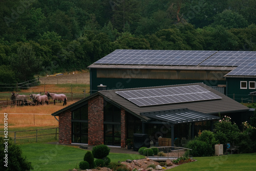 Warehouse with solar panels on the roof. Nature-produced energy. Sun-produced energy. Photovoltaic systems on the barn house in the countryside. Semiconductor technology. Carbonless footprint.