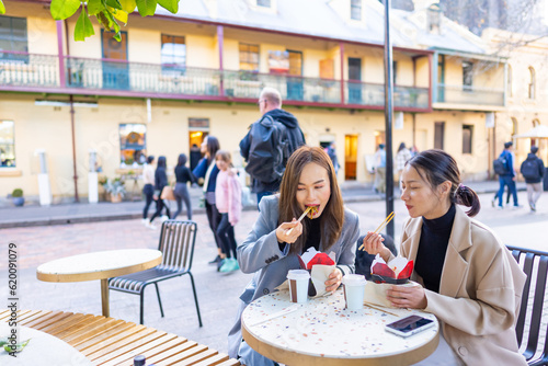 Photography Happy Asian woman friends having lunch at outdoor restaurant during shopping together in the city