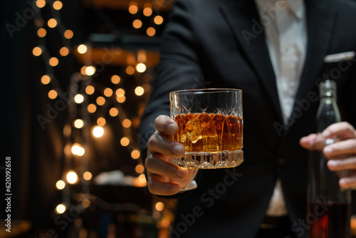 Bartender pours whiskey to customer in tavern