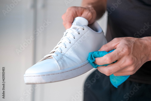  A man cleans white sneakers from dirt