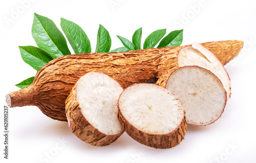 Cassava tubers with leaves and cassava slices isolated on white background. photo