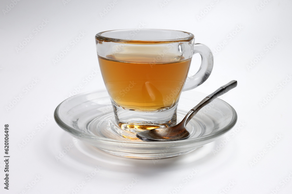 Hot tea in transparent glass cup saucer on white background Hot tea in transparent glass cup saucer on white background