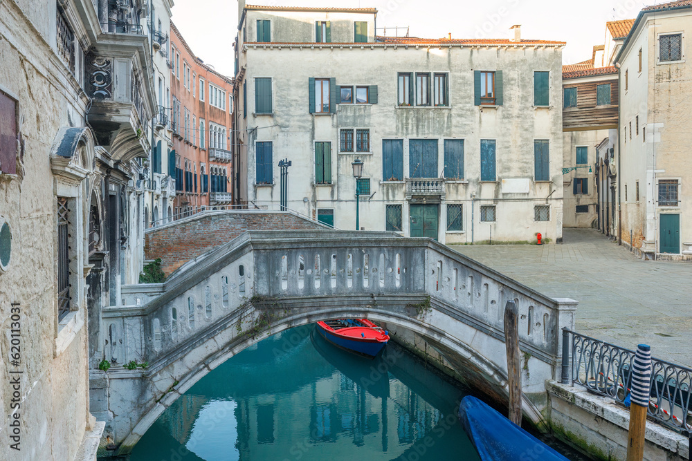Canal with stone bridge and historic buildings in Venice, Italy, Europe.