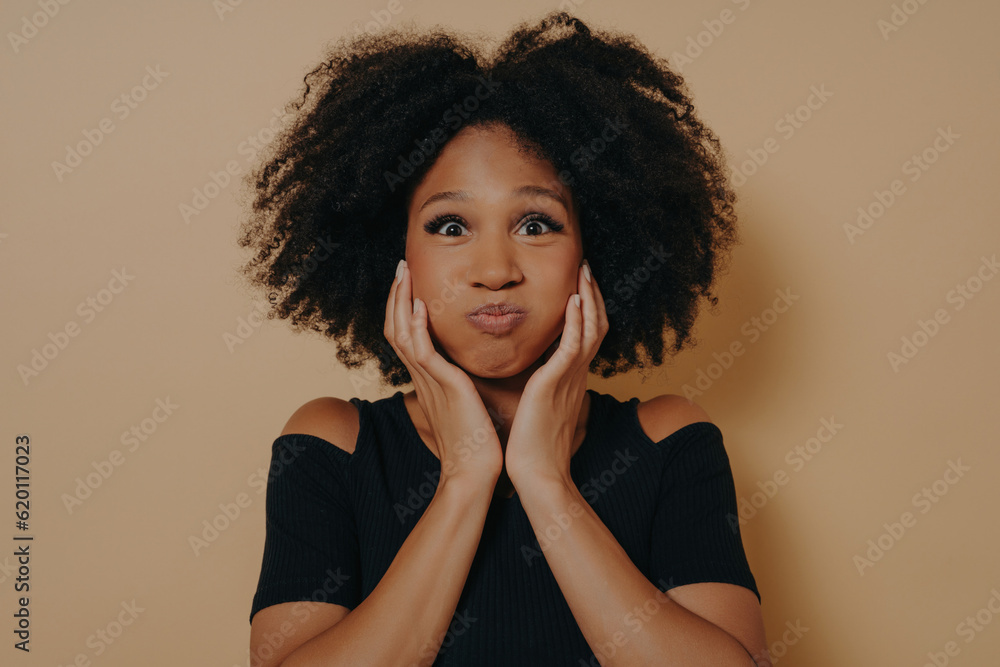 Indoor portrait of glamorous african model isolated on dark beige background with copy space Indoor portrait of glamorous african model isolated on dark beige background with copy space