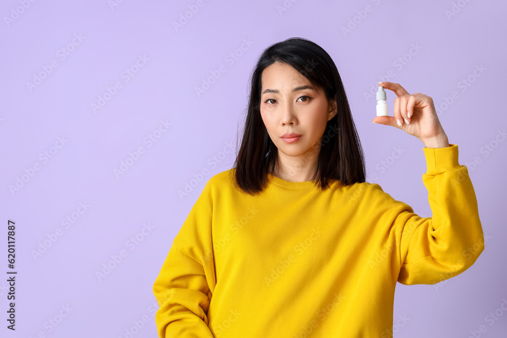 Allergic Asian woman with drops on lilac background Allergic Asian woman with drops on lilac background