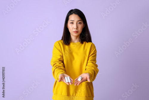 Allergic Asian woman with pills and drops on lilac background © Pixel-Shot