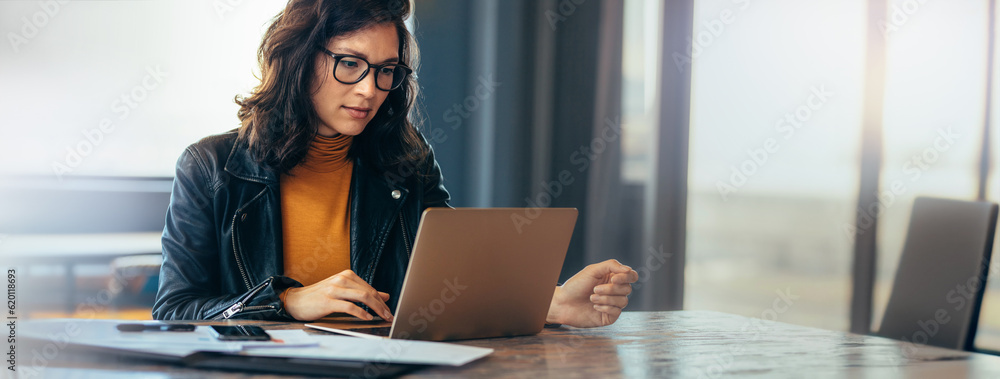 Asian business woman working on a laptop in a professional office - obrazy, fototapety, plakaty 