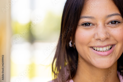 Portrait of happy biracial woman looking at camera and smiling, copy space