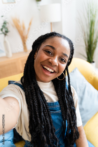 Smiling woman taking selfie from home.