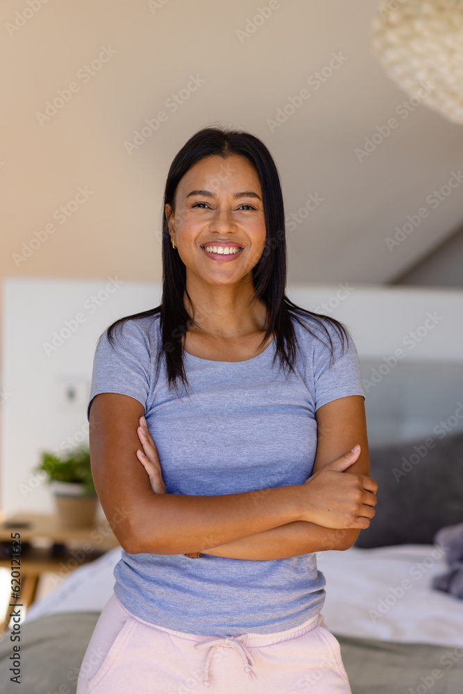 Portrait of happy biracial woman against beige wall in bedroom Portrait of happy biracial woman against beige wall in bedroom