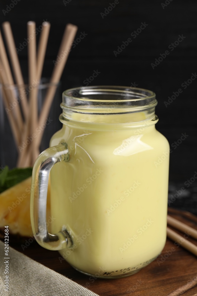 Tasty pineapple smoothie in mason jar on table, closeup Tasty pineapple smoothie in mason jar on table, closeup