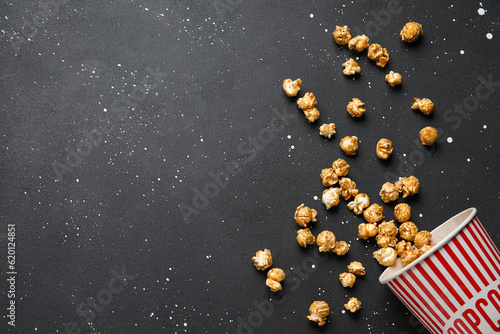 Bucket with tasty popcorn on black background