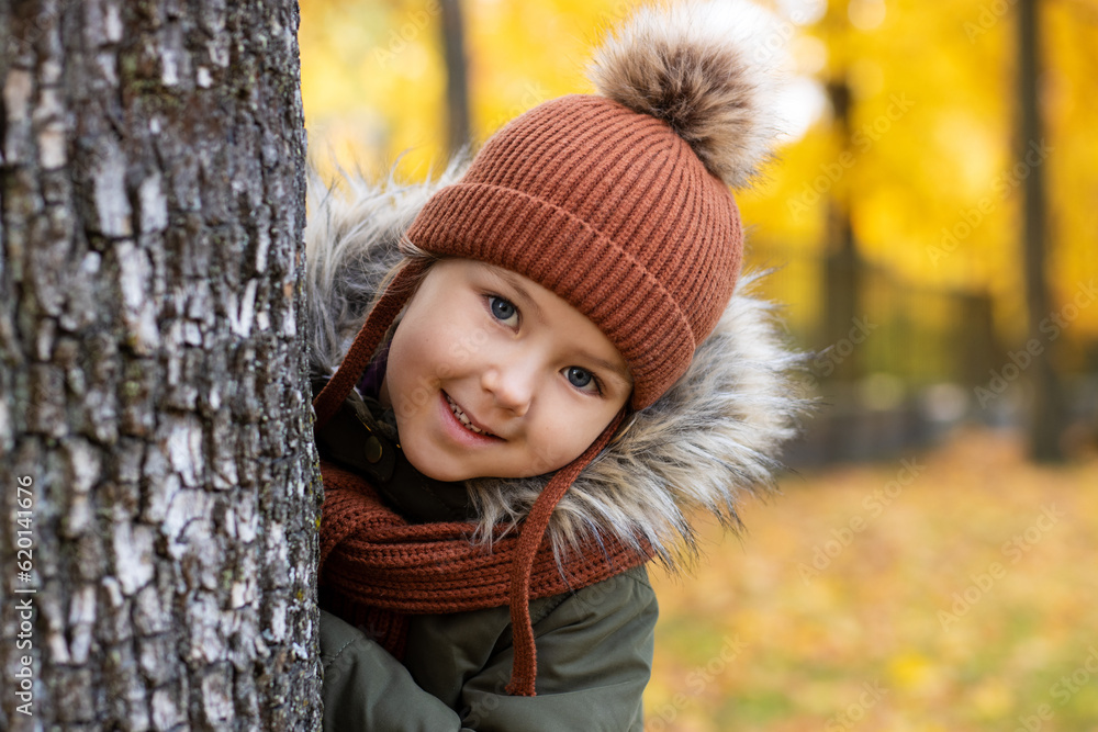 portrait of little girl peeking out from behind a tree portrait of little girl peeking out from behind a tree