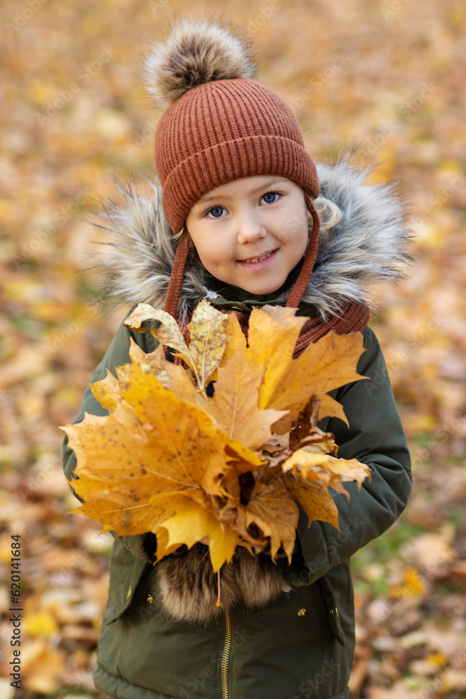 Cute little girl in autumn park with maple foliage Cute little girl in autumn park with maple foliage