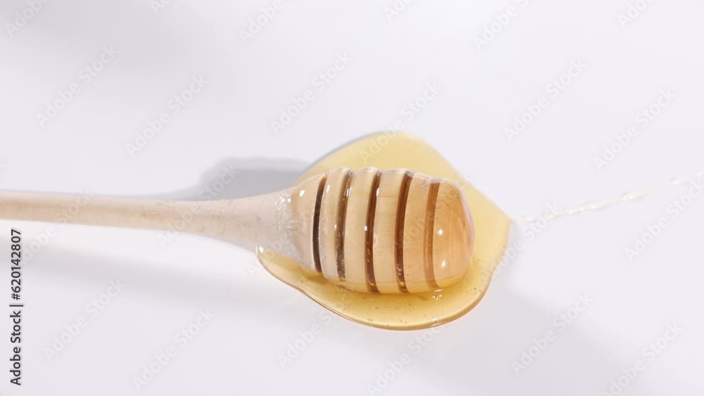 golden honey and wooden stick on white table golden honey and wooden stick on white table