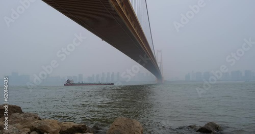 cargo ship shipping on Yangtze River under Yangsigang Yangtze River Bridge in Wuhan, Hubei, China photo