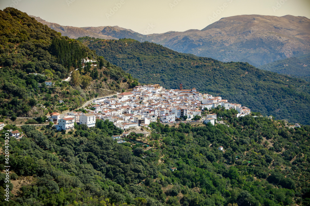 View in the distance of the white village of Algatocin, in the province of Malaga and between green mountains of the Serrania de Ronda View in the distance of the white village of Algatocin, in the province of Malaga and between green mountains of the Serrania de Ronda