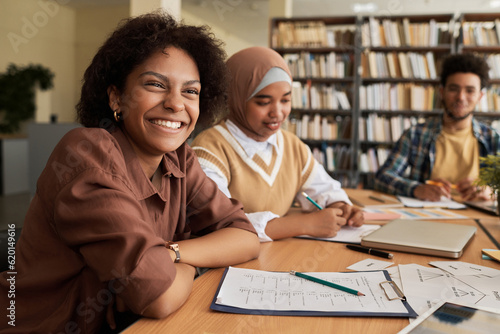 Group of students studying foreign language together at table in library