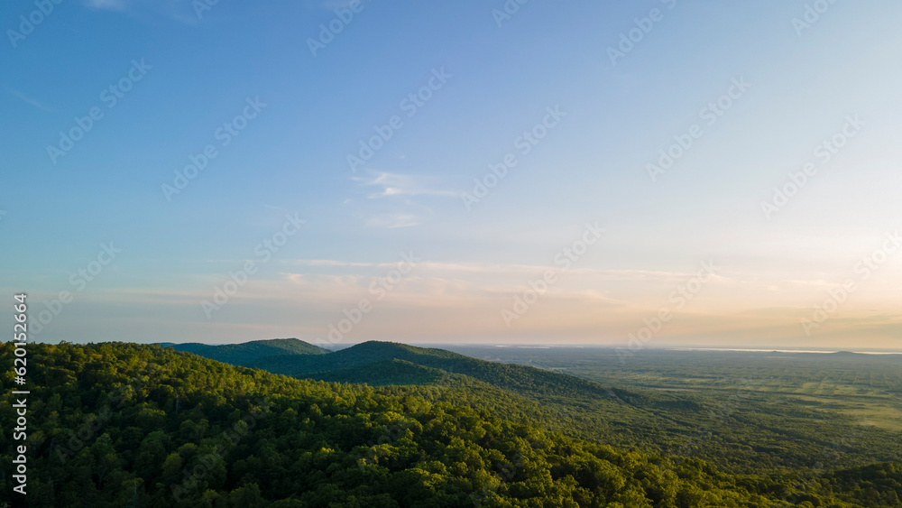 Naklejka premium Aerial view of the Peak of the mountain range and tall forest near to the river at summer cloud evening with horizon, color, sky