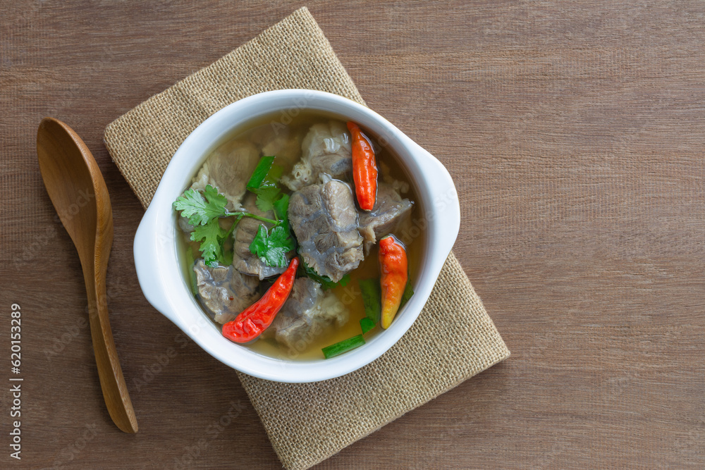top view of spicy tender boiled beef soup in a ceramic bowl on wooden table. asian homemade style food concept. top view of spicy tender boiled beef soup in a ceramic bowl on wooden table. asian homemade style food concept.