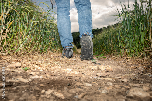 Low angle view of male feet in hiking boots stepping away from the camera