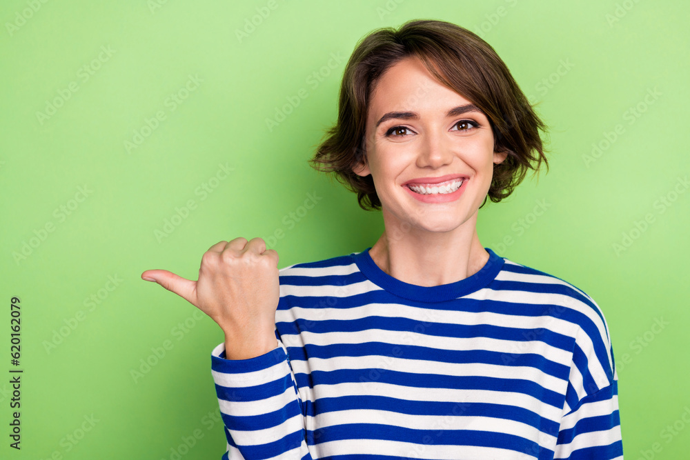 Photo of young beautiful manager pointing finger empty space mockup news wear blue striped shirt isolated green color background Photo of young beautiful manager pointing finger empty space mockup news wear blue striped shirt isolated green color background