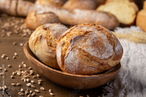 Bakery - Round bread close up. Freshly baked bread with a golden crust on rustic wooden background.