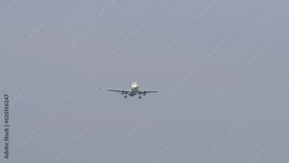 Civil plane approaching before landing. Commercial airplane flies, descending, front view. Long shot of airliner in the sky. Tourism and travel concept Civil plane approaching before landing. Commercial airplane flies, descending, front view. Long shot of airliner in the sky. Tourism and travel concept