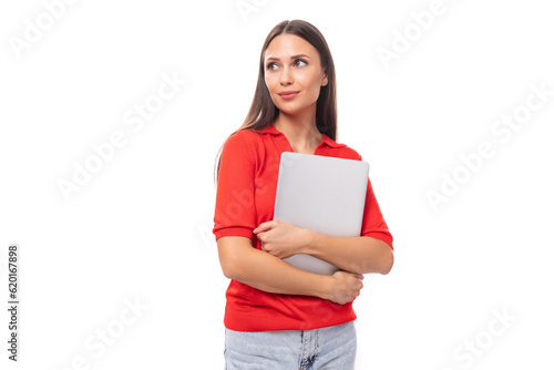 young smiling european woman student with dark straight hair is concentrated on work with holding a laptop in her hands
