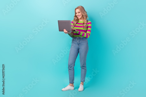 Full length photo of positive pretty lady wear striped pullover typing modern device isolated teal color background