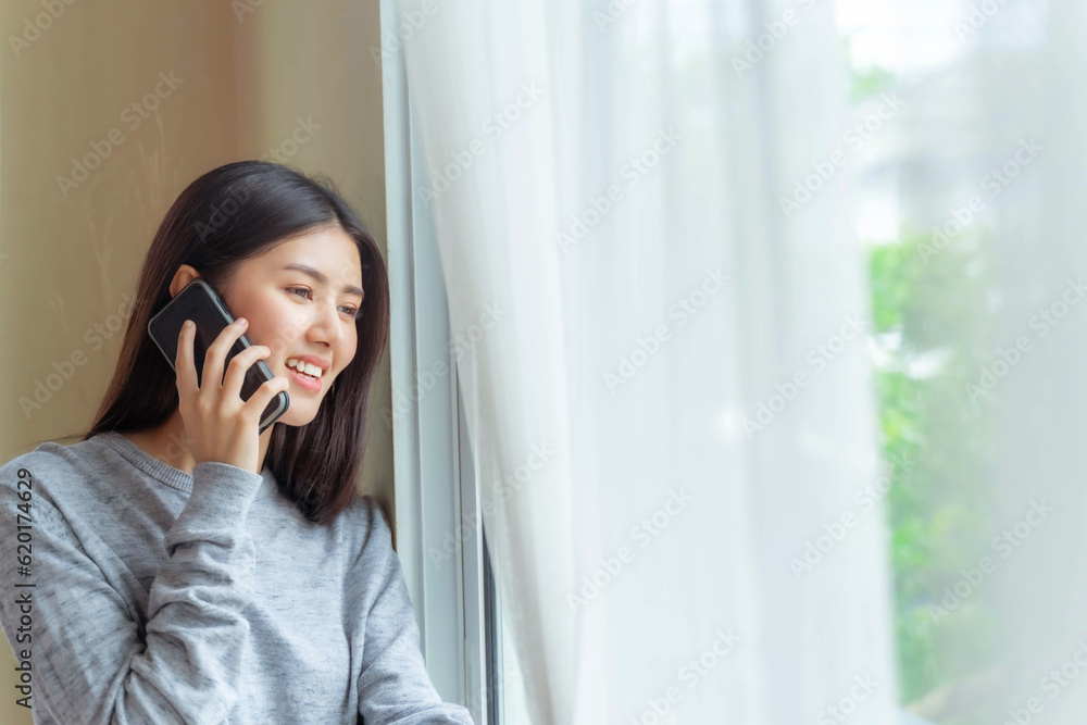 Lifestyle beautiful beauty woman Asian cute girl feel happy talking on smartphone to best friend in bedroom at home Lifestyle beautiful beauty woman Asian cute girl feel happy talking on smartphone to best friend in bedroom at home