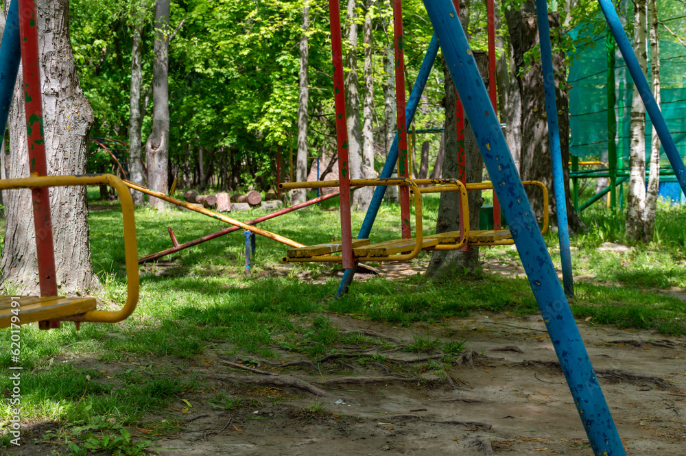 Empty multi-colored swing in the park on a summer day Empty multi-colored swing in the park on a summer day