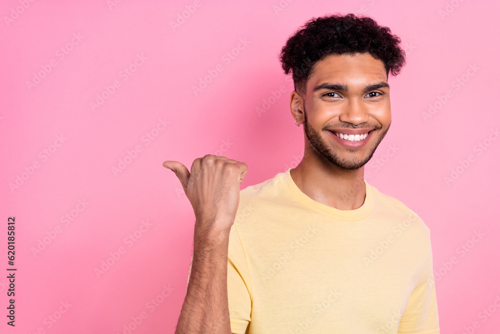 Close up photo of nice guy showing novelty object copyspace empty space wear shirt isolated pink color background Close up photo of nice guy showing novelty object copyspace empty space wear shirt isolated pink color background