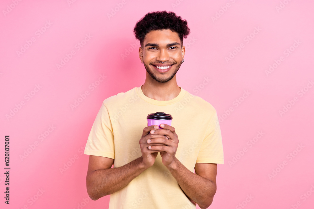 Portrait of optimistic satisfied nice man with afro hairstyle earrings stubble holding cup of coffee isolated on pink color background Portrait of optimistic satisfied nice man with afro hairstyle earrings stubble holding cup of coffee isolated on pink color background