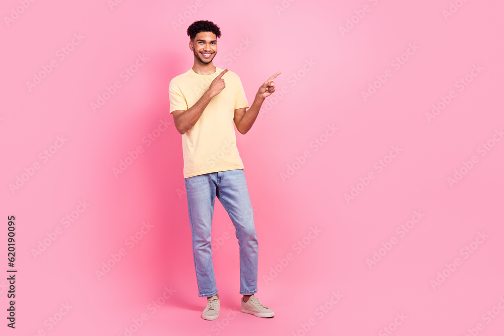 Full size photo of positive cheerful man wear yellow t-shirt jeans indicating at proposition empty space isolated on pink color background Full size photo of positive cheerful man wear yellow t-shirt jeans indicating at proposition empty space isolated on pink color background