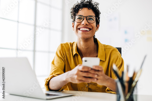 Professional black woman smiling and using a mobile phone