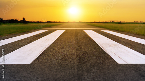 Fototapeta Naklejka Na Ścianę i Meble -  Runway at the airport in sunset sky