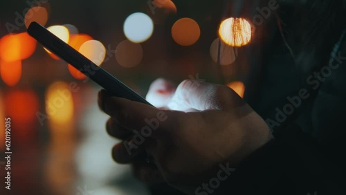 The phone is in female hands,fingers are typing text messages on social networks