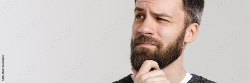 Obraz premium White puzzled man with beard posing and looking aside