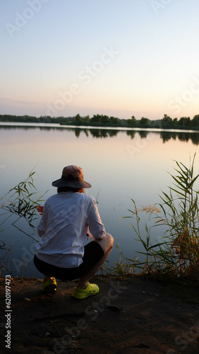 A girl on a fishing trip, a girl bybak, a girl in a tourist Panama hat catches fish