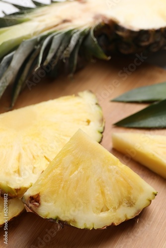 Slices of ripe pineapple on wooden board, closeup