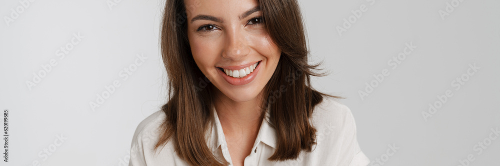 Young european woman in shirt smiling and looking at camera Young european woman in shirt smiling and looking at camera
