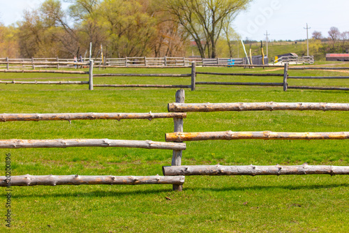 Wooden fence on the green grass in the spring. Natural background