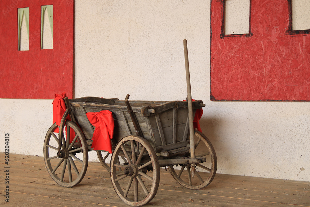 alter Handwagen mit roten Schleifen
dekoriert
