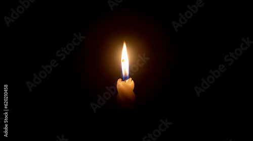 A single burning candle flame or light glowing on a white spiral candle on black or dark background on table in church for Christmas, funeral or memorial service with copy space.