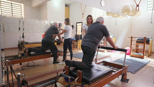 Pilates Instructor Guiding Senior Man, Physiotherapy Session with Exercise Machine